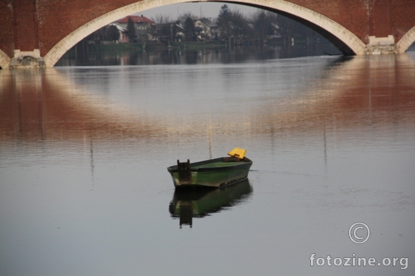 jedan usamljeni čamac koji gleda most
